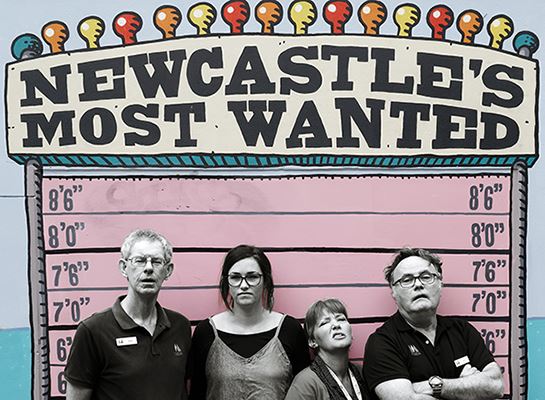 Museum staff infront of Newcastle's most wanted sign